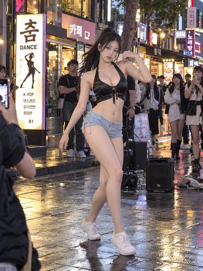 Korean Street Dancer Pauses Under Warm Neon Cafe Signs