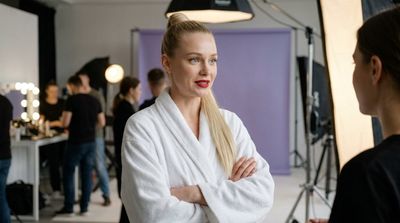 Blonde model in white robe feels nervous excitement before shoot