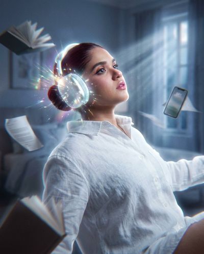A woman floats in zero gravity while glowing headphones radiate light.