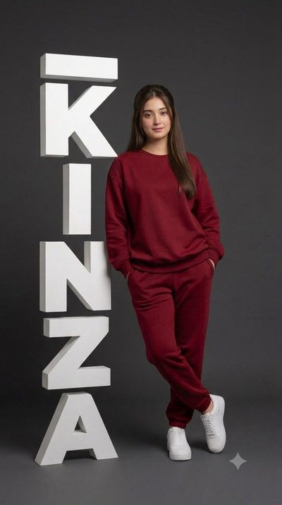 Woman in red leans against giant 3D letters Janaki