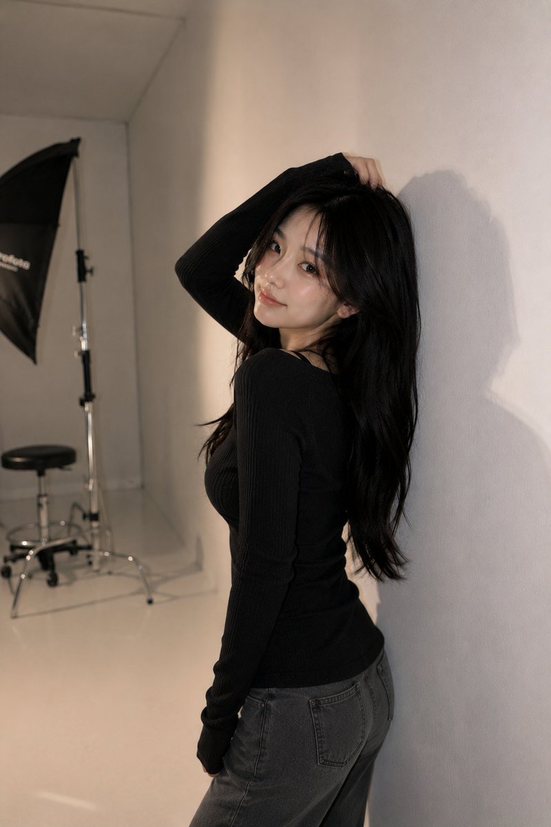Korean model poses elegantly against gray studio wall with soft lighting