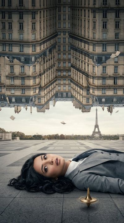 A woman lies on Paris plaza as the city folds down from above