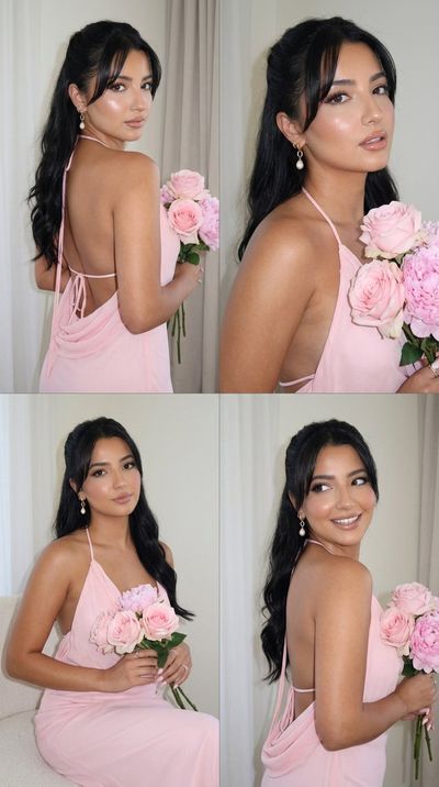 Woman in pink dress holds flowers over her shoulder with soft gaze