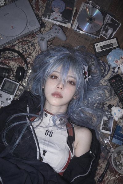 Two cosplay characters lie on a cluttered floor under soft flash