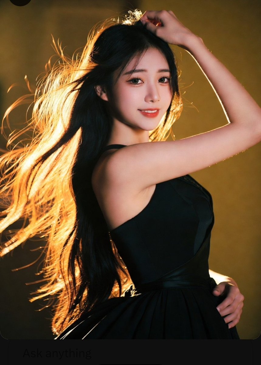 Golden rim light highlights elegant black dress and flowing hair