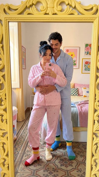 A couple takes a cozy mirror selfie in matching pajamas