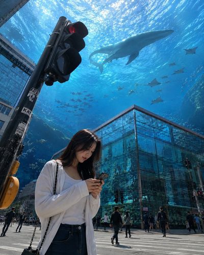 A Young Woman at a Traffic Light Under a Floating Ocean