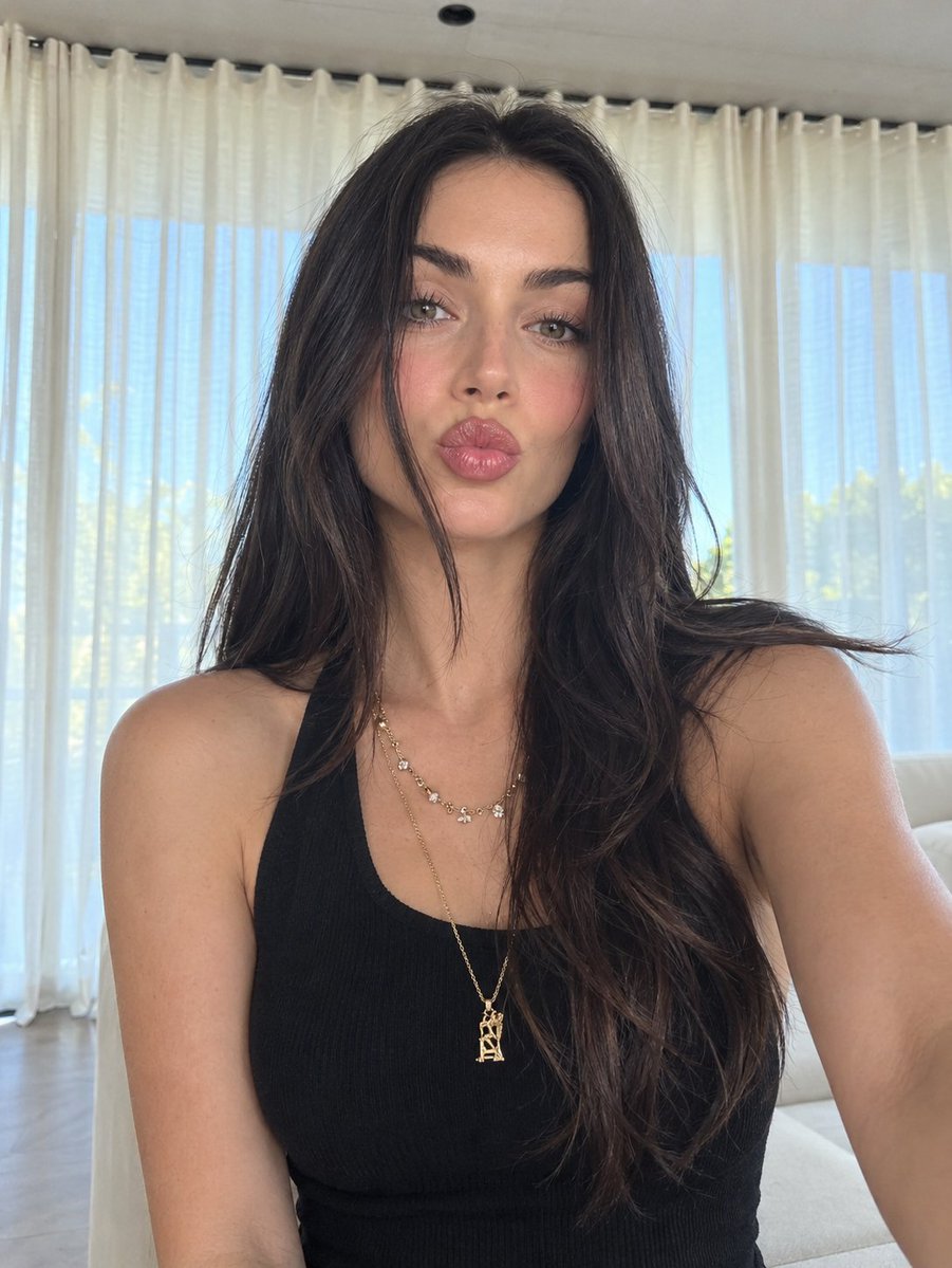 Young woman takes a close-up selfie in bright modern living room