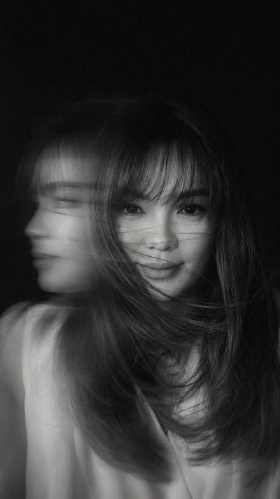 Woman's blurred face emerges from sweeping hair in motion