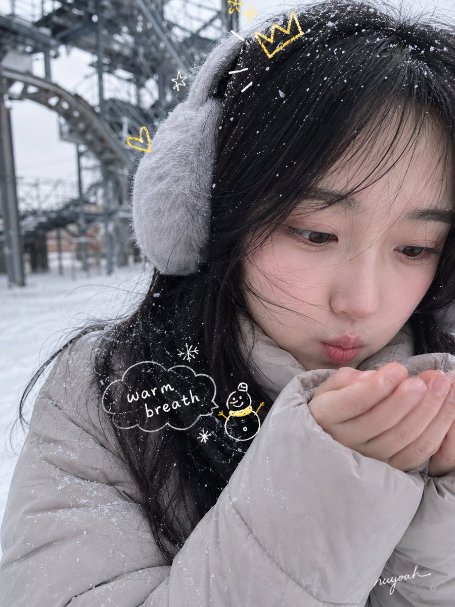A cute girl in a fluffy coat smiles softly amid gentle snowfall