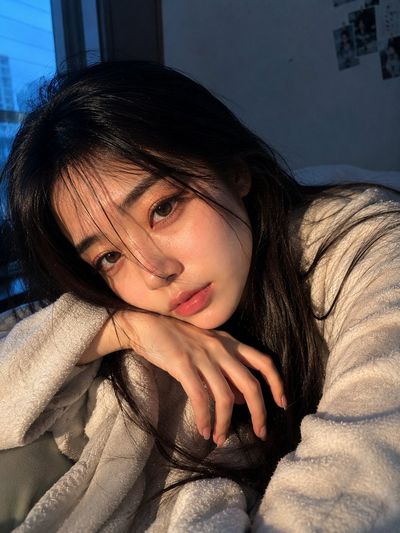 East Asian woman gazes at camera with one visible eye