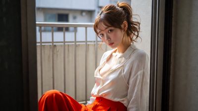 Japanese woman in silk camisole poses on balcony with laundry