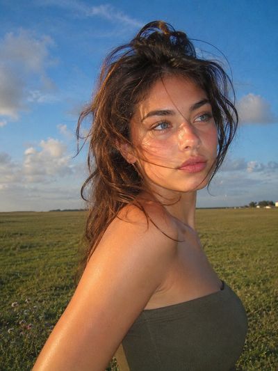 Young woman in meadow glows in warm golden hour light