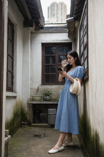Young woman checks phone in Shanghai shikumen tianjing courtyard