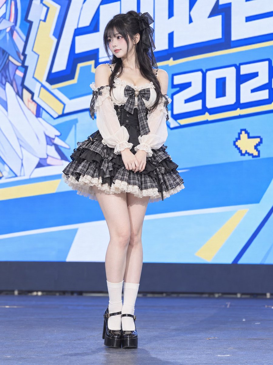 Gothic Lolita girl stands quietly on blue-lit convention stage