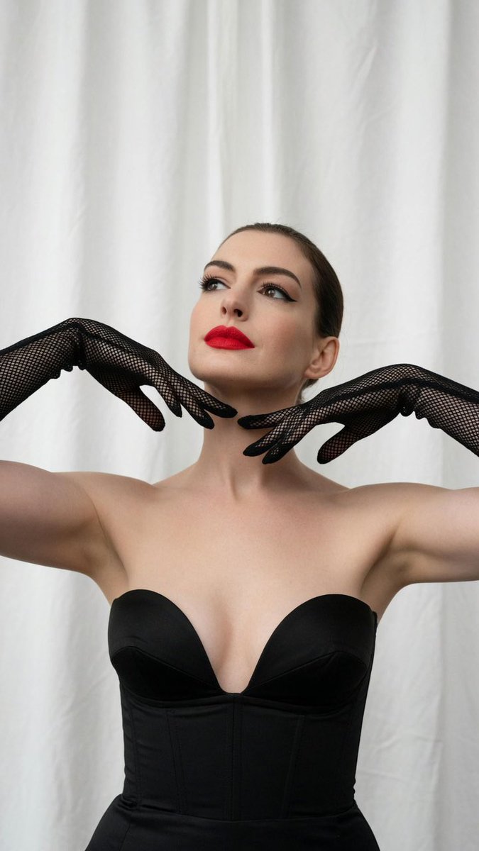 Anne Hathaway poses with white fishnet gloves in studio light