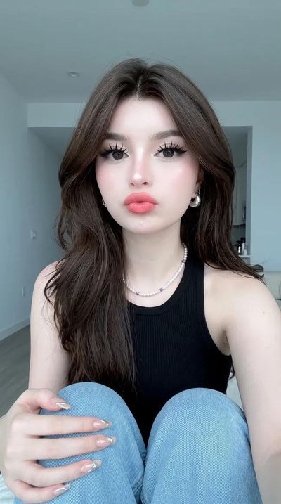 Young woman with glass skin pouts in a minimalist bedroom selfie