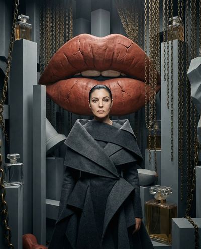 Stoic muse stands centered among surrealist sculptures and chains