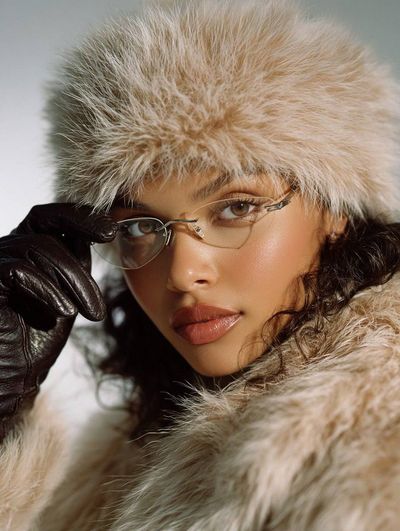 A woman in fur adjusts her glasses in a 90s editorial