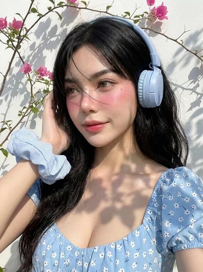 Young woman with windblown black hair gazes softly at camera