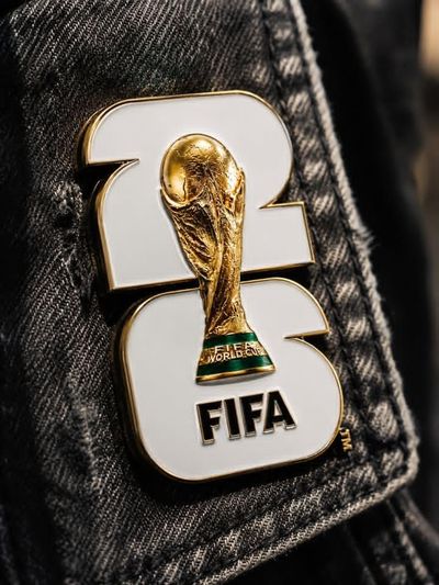 Golden World Cup pin gleams on black denim with sharp detail