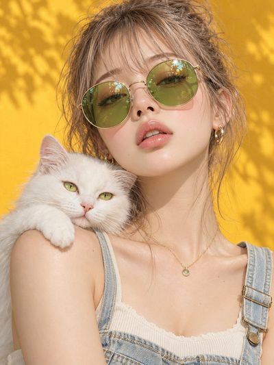 Woman with White Cat on Shoulder Before Yellow Wall