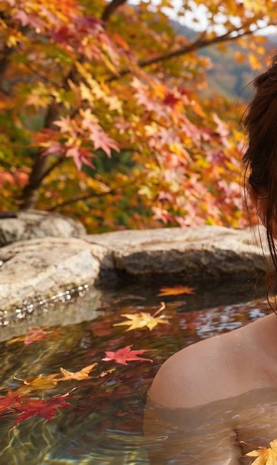 Serene Japanese Woman Soaks in Onsen Amidst Autumn Maple Leaves