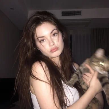 Woman holds a cat in a softly lit night portrait