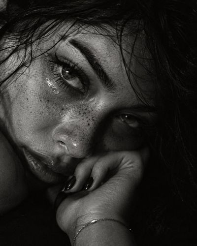 Intimate Black and White Portrait Captures Woman's Tearful Gaze in Shadow