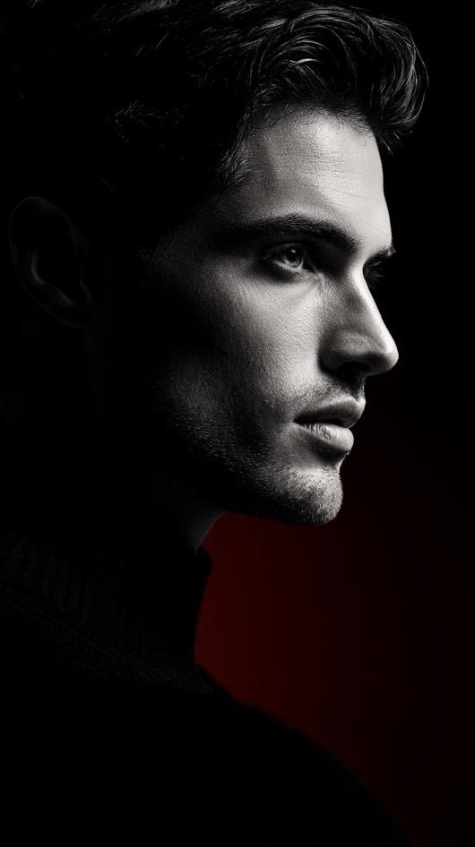 Side profile portrait illuminated by dramatic high contrast lighting