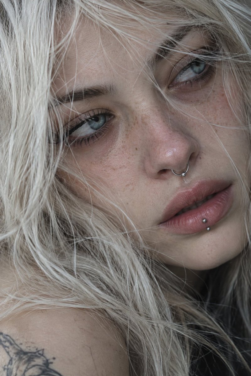 Platinum-Haired Woman With Piercings Gazes Away in Raw Portrait