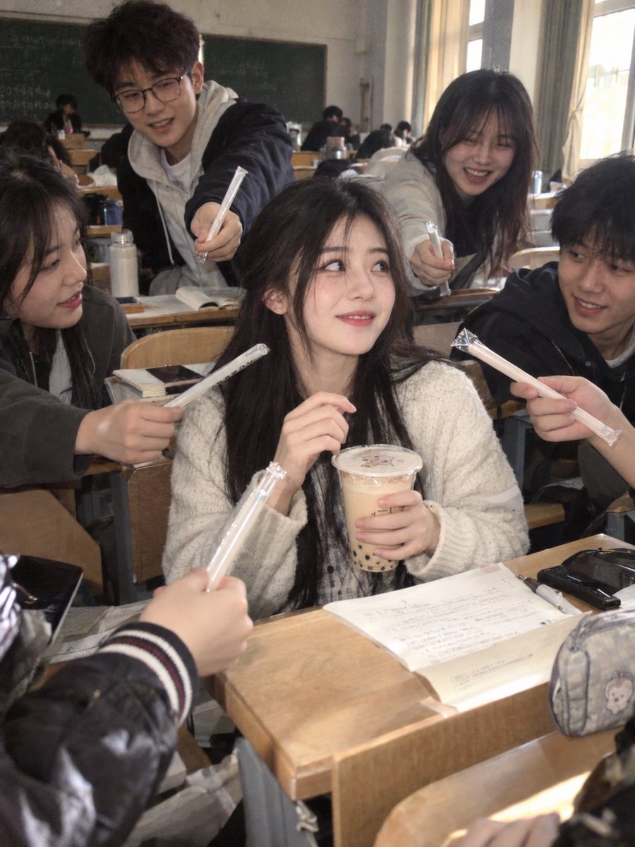 Classroom Beauty Surrounded by Students Offering Straws for Milk Tea