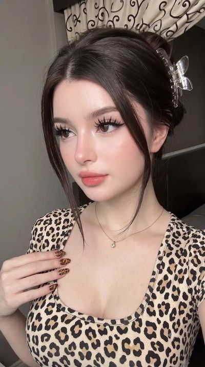 Woman with porcelain skin in leopard top looks directly at camera