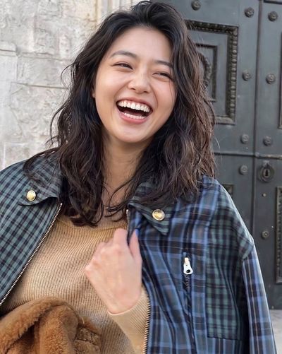 Joyful Woman Laughing in Autumn Stone Alley Wearing Tartan Jacket