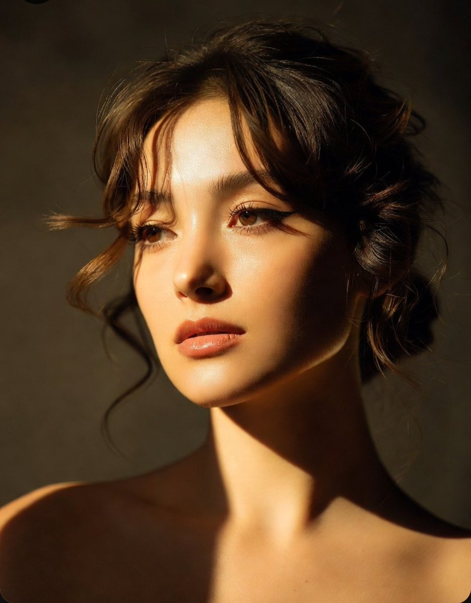 Golden hour sunlight sculpts a woman's serene profile in dramatic portrait