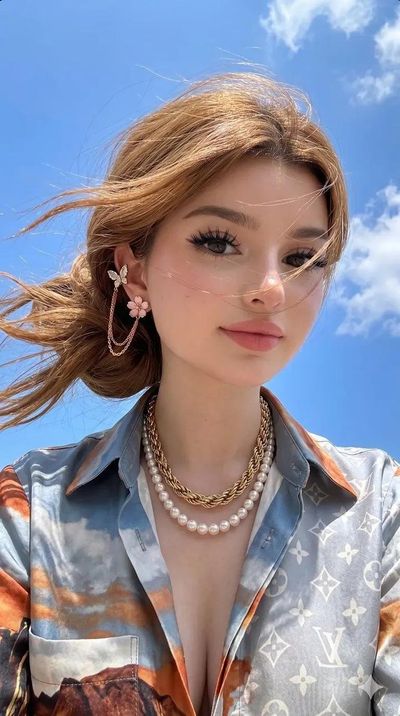 Young woman in golden hour light wears butterfly earrings