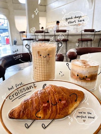 A smiling iced coffee and pastry sit on a cozy café table