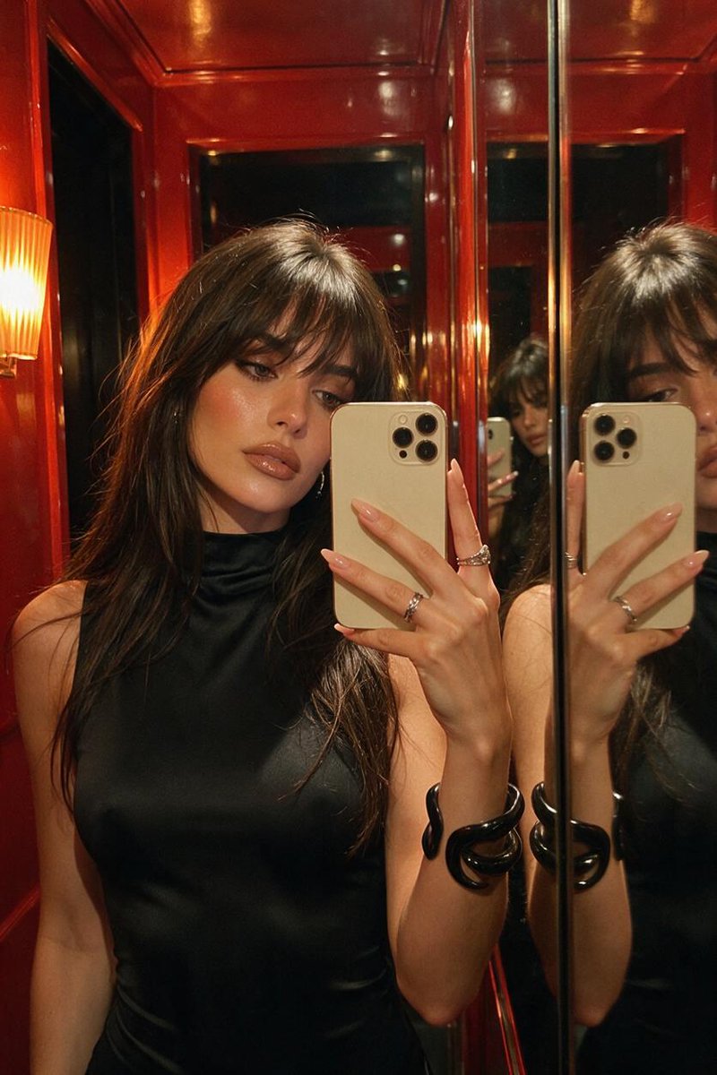 Woman Takes Mirror Selfie in Glossy Red Dressing Room at Night