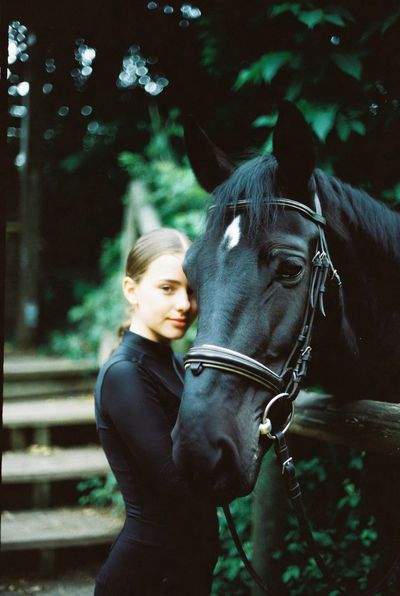 Nocturnal Bond: Racer and Black Horse in Retro Film Glow