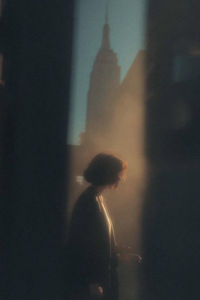Silhouette of Serenity: A Golden Glimpse in Urban Shadows