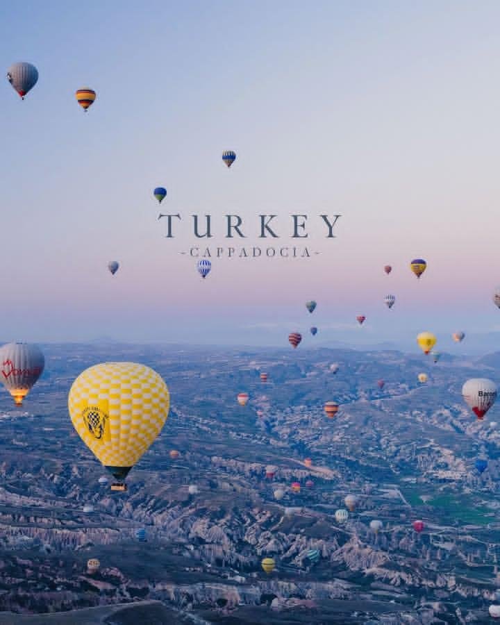 Turkey's Cappadocia floats under a pastel sunrise sky