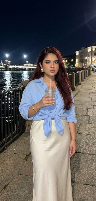 Young woman holds iced coffee during late night St. Petersburg walk