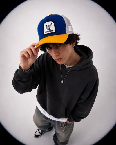 Young man in charcoal hoodie looks up through fisheye lens