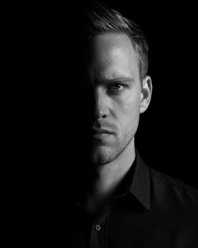 A dramatic monochrome portrait with split lighting and deep shadows