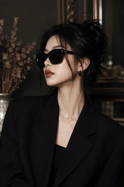 A young woman in a black blazer poses with a mysterious gaze