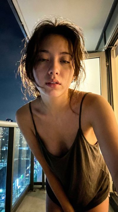 Late Night Balcony Selfie with Soft Light and City Glow