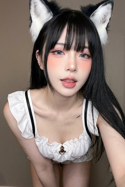 A woman in a cat-ear headband takes a playful selfie