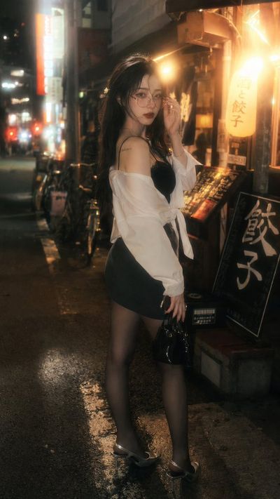 Glowing lanterns frame a tired idol on a wet night street