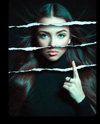 Teal-eyed woman behind torn paper strips whispers secrets in moody light