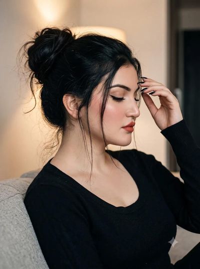 Serene South Asian woman closes her eyes beside warm light